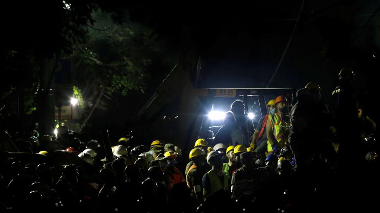 Rescuers and people work at a collapsed building