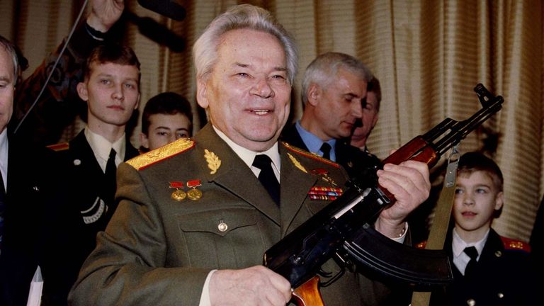 Mikhail Kalashnikov, pictured in 1997, holds aloft an AK-47