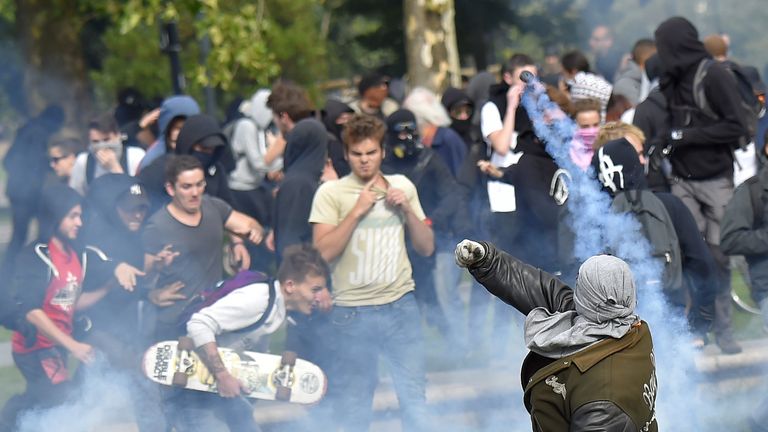 A protester (R) throws back a tear gas canister in Nantes