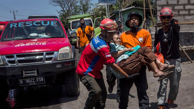 An elderly woman is evacuated from her village by rescue workers