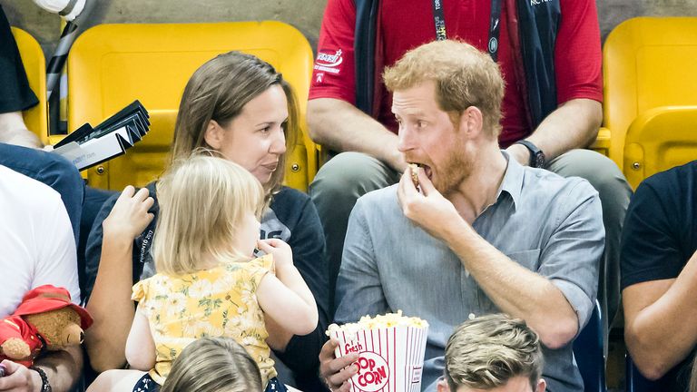 Prince Harry tucks into his popcorn 