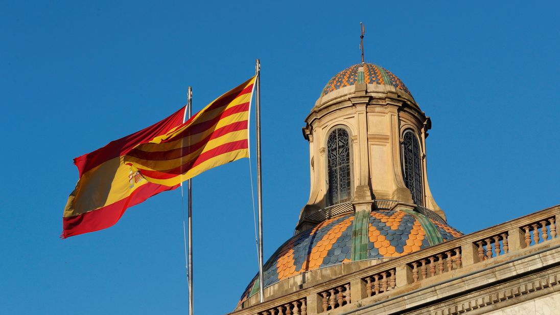 Spanish (L) and Catalan flags flutters atop the Generalitat Palace, the Catalan regional government headquarter in Barcelona, Spain, October 30, 2017. REUTERS/Yves Herman