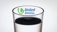 The logo of water company United Utilities seen through a glass of water