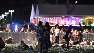 Festival-goers hold each other after the deadliest mass shooting in US history