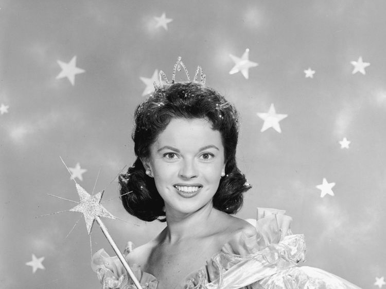 1958: American actor Shirley Temple wears a fairy godmother costume, which includes a magic wand and a tiara, in a promotional portrait for her television series of dramatized fairy tales, 'Shirley Temple's Storybook'. (Photo by Hulton Archive/Getty Images)