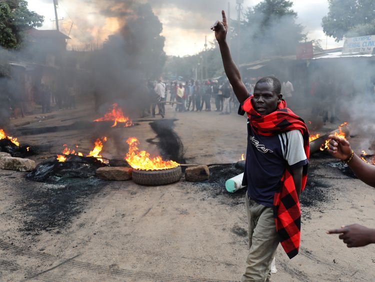 
KENYA-ELECTION/RTX3I5GJ25 Oct. 2017Nairobi, KenyaAn opposition supporter gestures in front of a burned barricade in Kibera slum in Nairobi, Kenya October 25, 2017. REUTERS/Goran Tomasevi