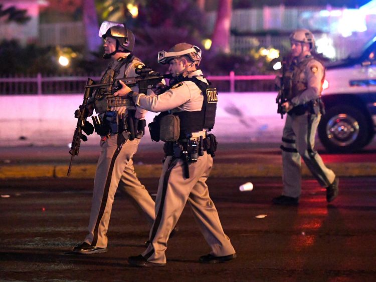 Police officers point their weapons at a car driving down closed Tropicana Ave