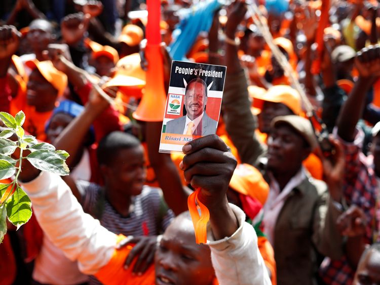 An opposition supporter holds up a picture of opposition leader Raila Odinga during a rally in Nairobi..