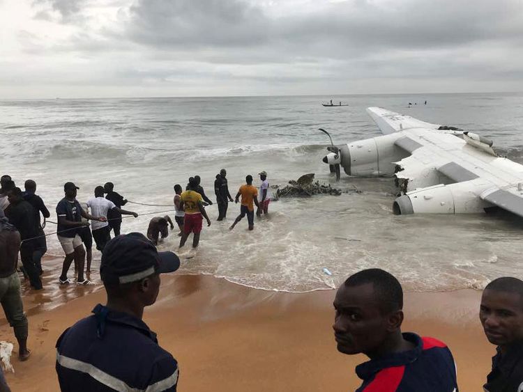 People pull items from the sea after a military-chartered plane crashes in Ivory Coast