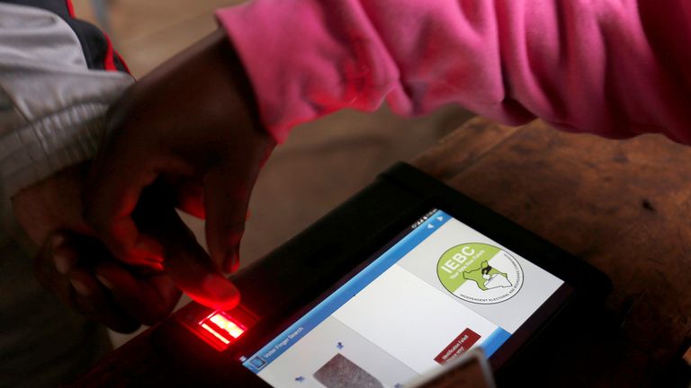 An election official uses an electronic device to check a voters&#39; identity at a polling station in the capital