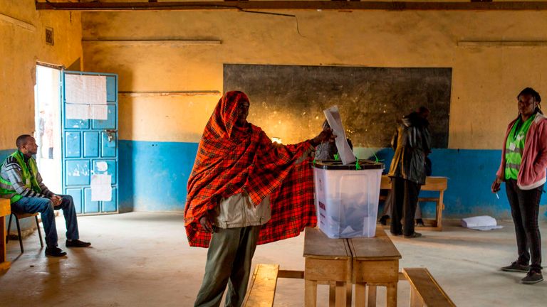 A member of the Maasai and Kikuyu tribe votes at a polling station at a school in Masailand
