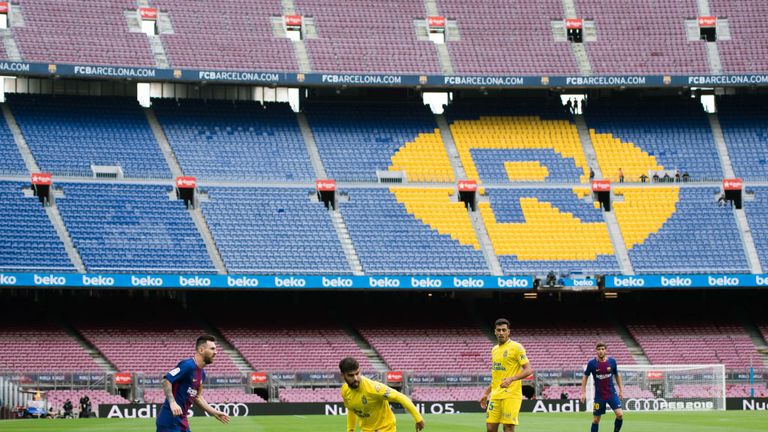 Lionel Messi plays the ball in front of an empty Nou Camp after a decision was made to play behind closed doors