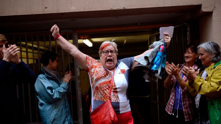 A woman celebrates outside a polling station after casting her vote in Barcelona