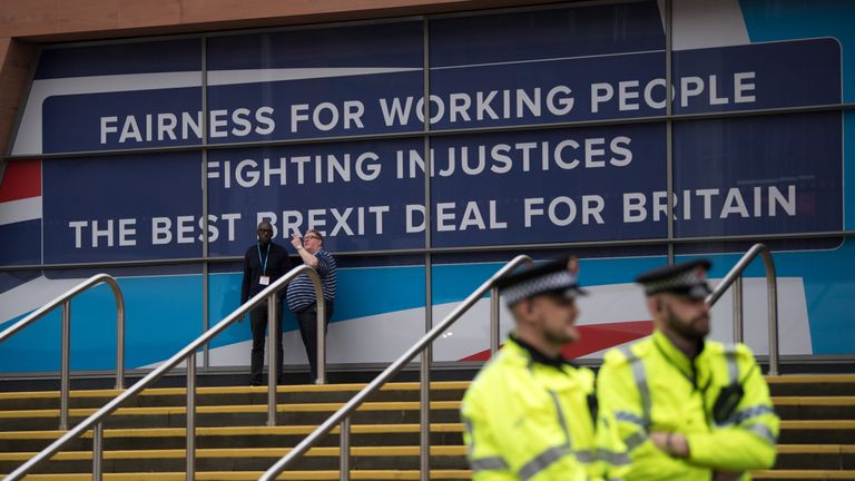 MANCHESTER, ENGLAND - OCTOBER 01: Police officers stand in front of a poster on the first day of the annual Conservative Party conference, October 1, 2017 in Manchester, England. Ministers and senior party members will address delegates throughout the day with a number of speeches discussing the party's plans for the next twelve months. (Photo by Carl Court/Getty Images)
