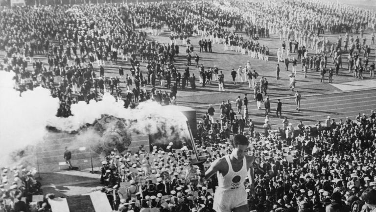 Sakai mounts the steps to light the cauldron at the opening ceremony of the Summer Olympic Games