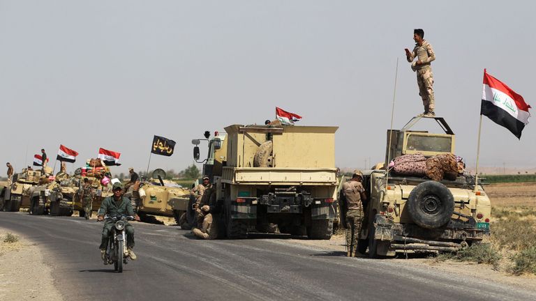 Iraqi forces rest on the road as they drive towards Kurdish peshmerga positions on October 15, 2017, on the southern outskirts of Kirkuk