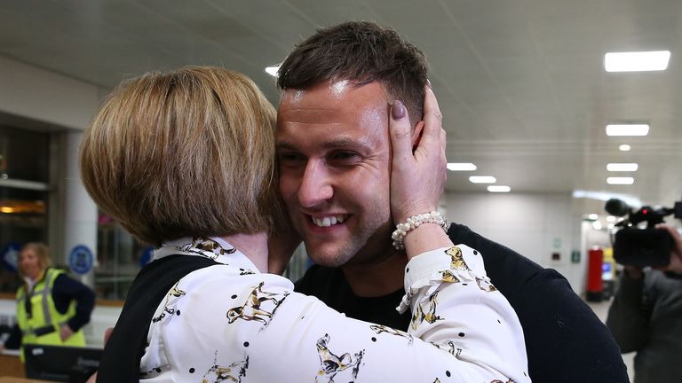 Jamie Harron, who was sentenced to three months in a Dubai jail for touching a man&#39;s hip, hugs his mother Patricia after arriving at Glasgow Airport