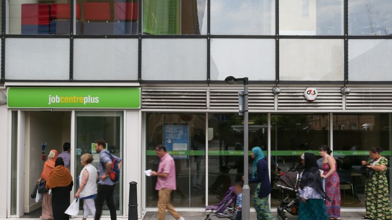 People queue to enter a job centre in east London