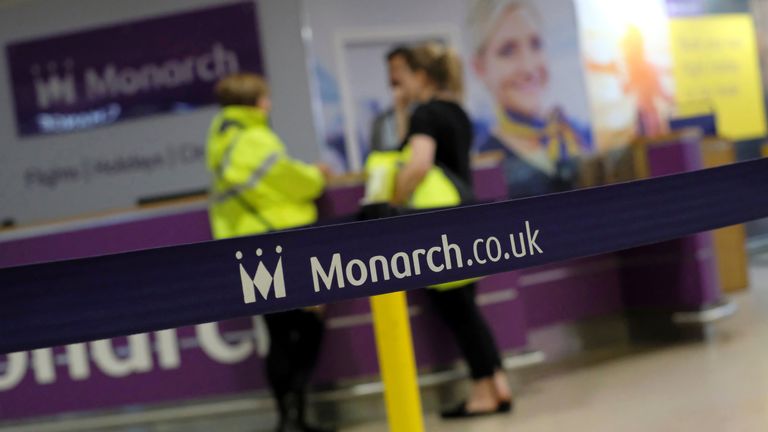 Airport staff speak by empty Monarch Airlines check-in desks after the airline ceased trading at Birmingham Airport, Britain October 2, 2017.