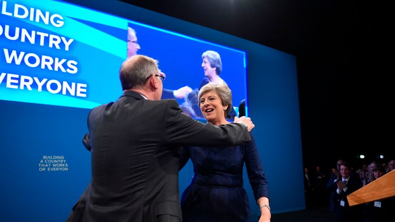 Britain&#39;s Prime Minister Theresa May (R) is hugged by her husband Philip May (L) on the stage at the end of her speech on the final day of the Conservative Party annual conference at the Manchester Central Convention Centre in Manchester, northwest England, on October 4, 2017