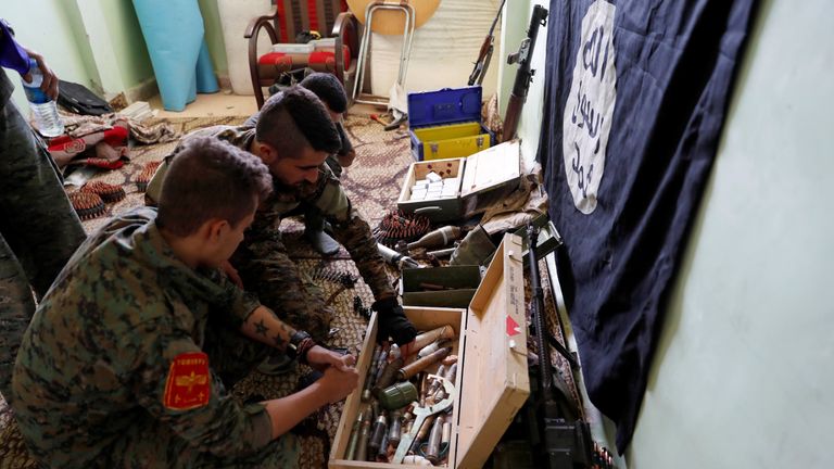 Fighters of Syrian Democratic Forces inspect weapons and munitions recovered at the former positions of the Islamic State militants