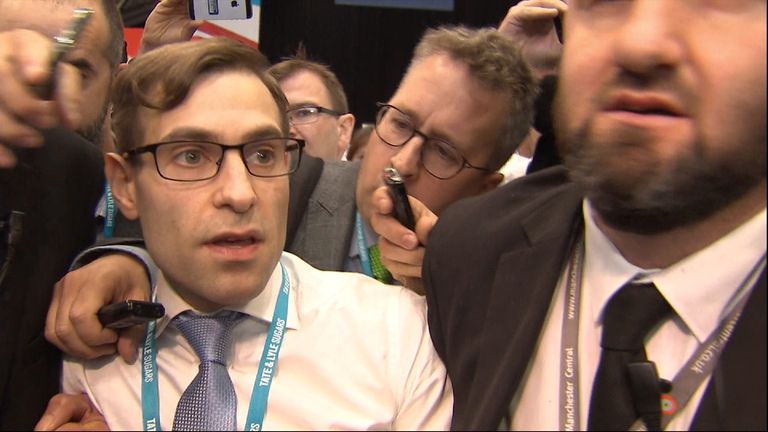 Simon Brodkin is led out of the conference hall in Manchester after handing a P45 form to the Prime Minister