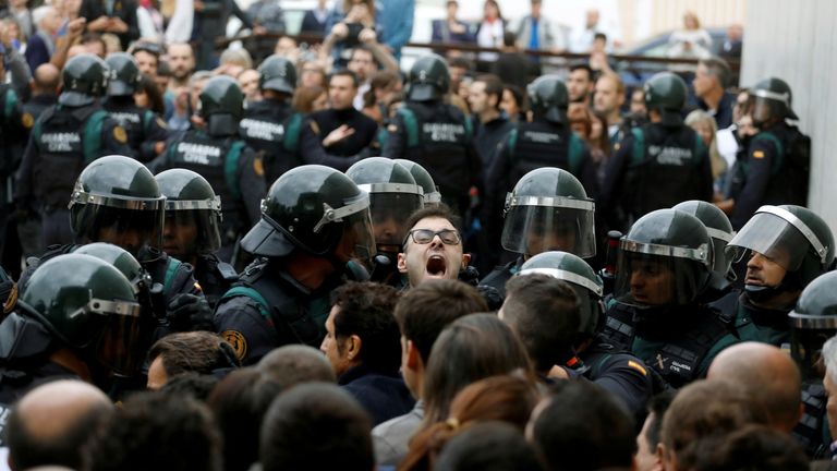 A man shouts as officers force their way through a crowd