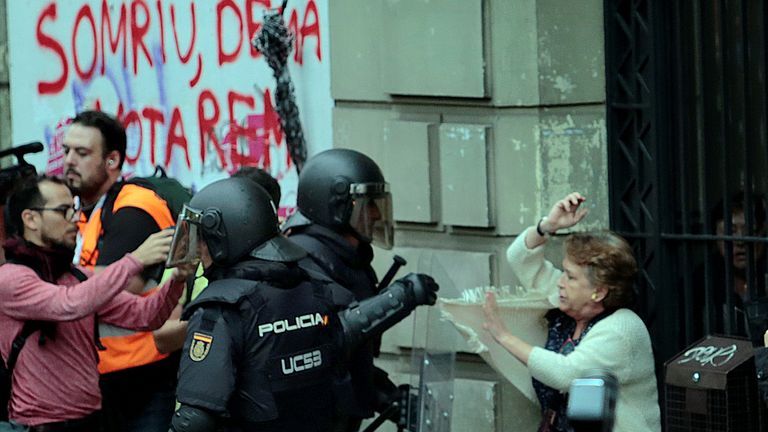 A woman is grabbed by riot police near a a polling station