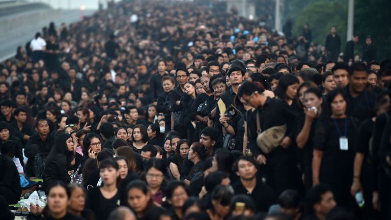 Mourners wait for the funeral procession of King Bhumibol in Bangkok