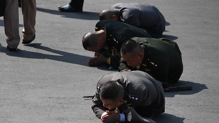 Members of the military prostrate as the royal urn passes during the funeral procession