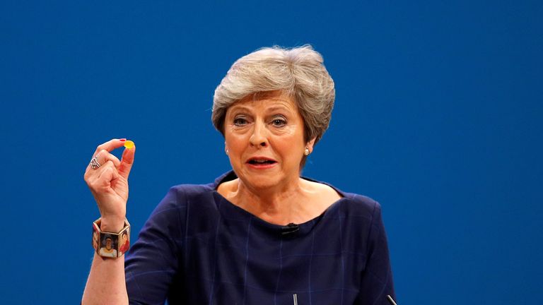 Theresa May holds up a cough sweet after suffering a coughing fit whilst addressing the Conservative Party conference 