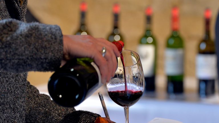 Wine being poured into a glass at a tasting in Saint-Emilion, France