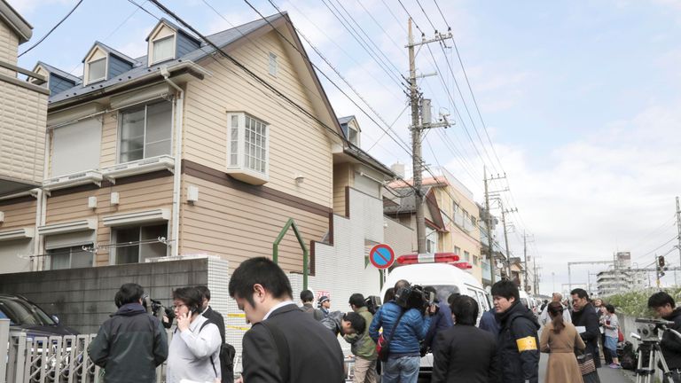 Media gather outside the apartment where nine bodies were found. Pic: Kyodo/Reuters