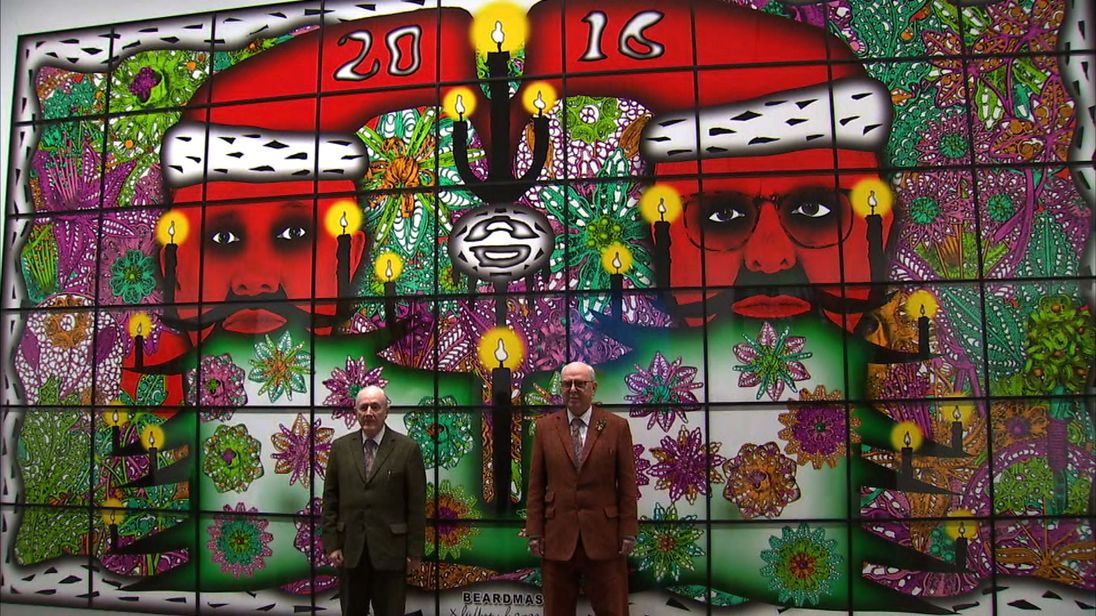 Gilbert and George stand in front of one of their pieces