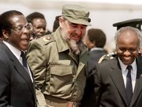 1986: Cuban President Fidel Castro (C) shares a laugh with Zimbabwean President Canaan Banana (R) and Zimbabwean Prime Minister Robert Mugabe (L) as he arrives in Harare