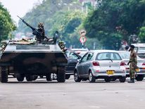 An armoured personnel carrier stations by an intersection as Zimbabwean soldiers regulate traffic in Harare