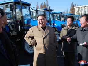 North Korean leader Kim Jong Un laughed with tractor factory bosses in his first public outing in two months