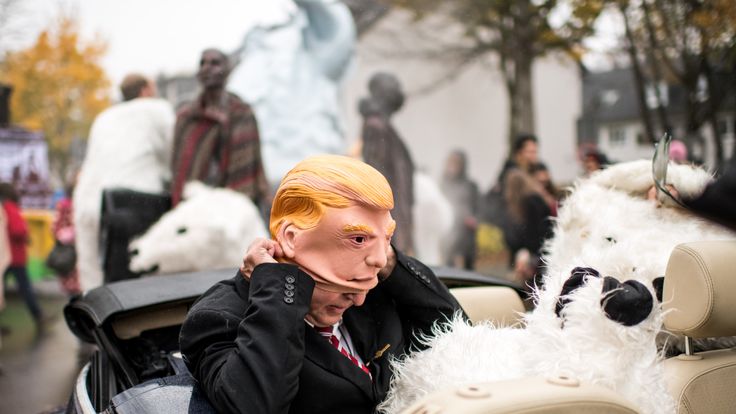 A climate change activist wears a mask of Donald Trump during a protest march near the venue of the COP 23 United Nations Climate Change Conference on November 11, 2017 in Bonn, Germany