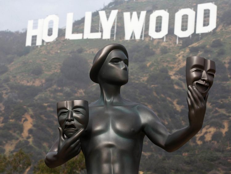 A Screen Actors Guild statue is seen in front of the Hollywood sign in Los Angeles