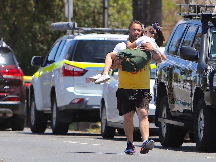 A man carries a young girl away from the scene of the horrific crash