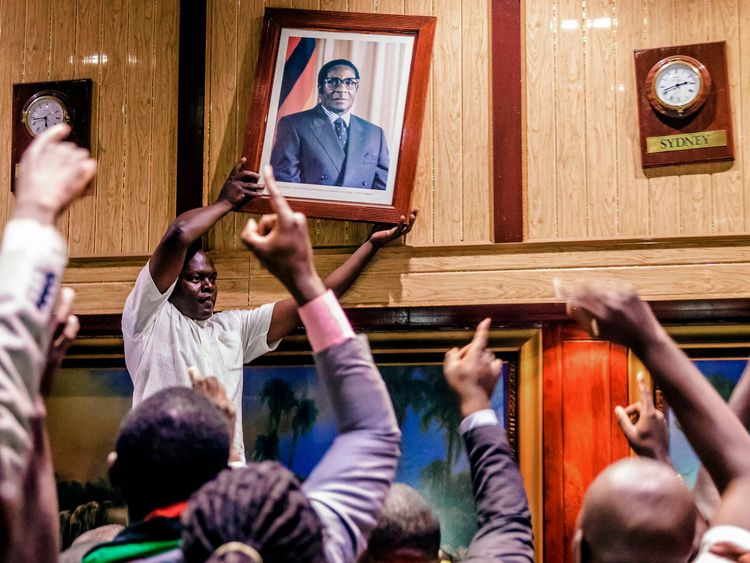 Mugabe&#39;s portrait is removed from a wall in Harare&#39;s International Conference centre