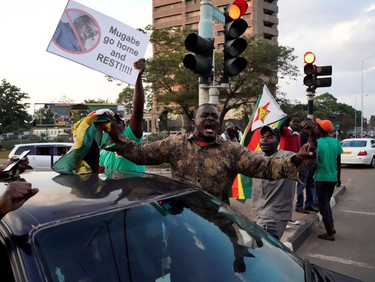 People celebrate in the streets after the resignation of Zimbabwe&#39;s president Robert Mugabe