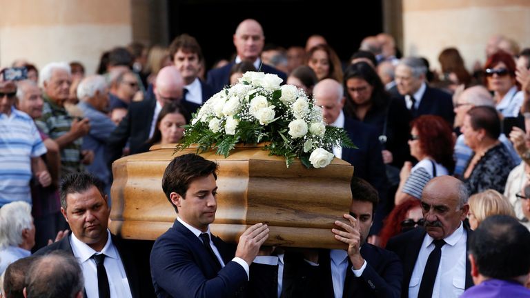 The journalists&#39;s sons, Matthew and Paul, carry their mother&#39;s coffin