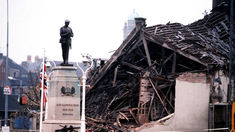 1987: The Cenotaph at Enniskillen with the devastated community centre in the background. 11 people died and more than 50 were injured in a massive IRA bomb explosion just before a Remembrance Day ceremony 