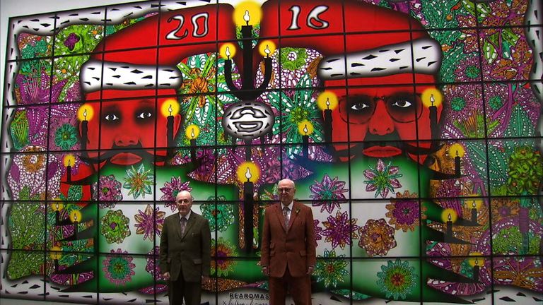 Gilbert and George stand in front of one of their pieces