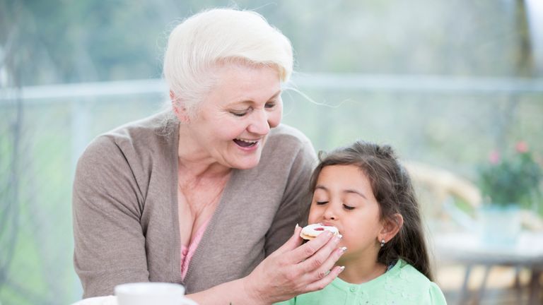 A grandmother feeds a biscuit to her granddaughter. File pic