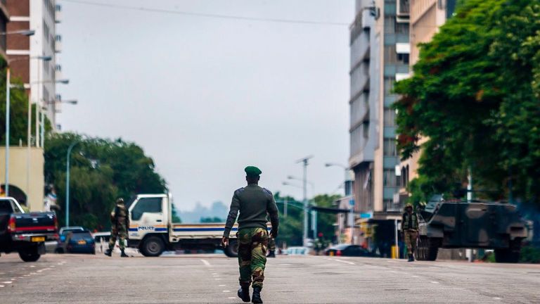 A soldier walks down a deserted main road in central Harare