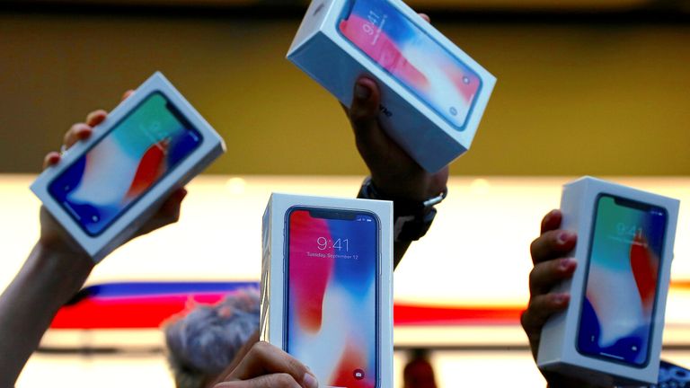 Customers hold up newly purchased iPhone Xs outside the Apple store in Sydney