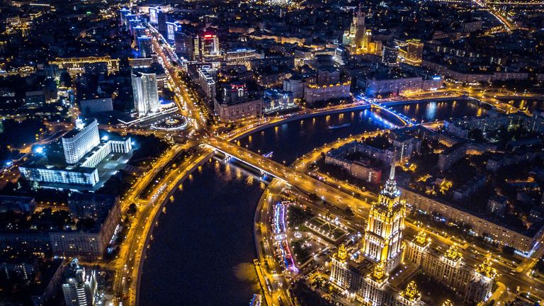 An aerial view taken with a drone on late August 12, 2017 shows the Radisson Royal Hotel (R) opposite the Russian government headquarters (L) as boats pass on the Moskva River in Moscow