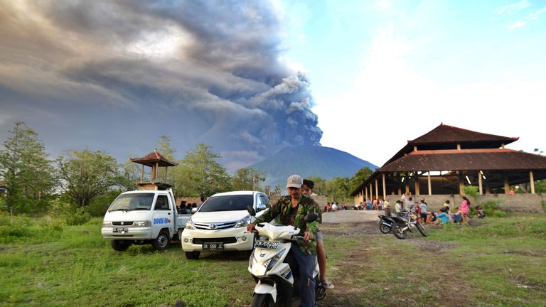 Balinese people look at Mount Agung during an eruption seen from Kubu sub-district